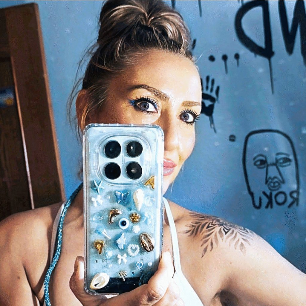 Chica en el espejo mostrando su funda personalizada Evo Charms con detalles dorados